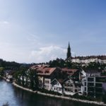 houses near body of water under blue sky during daytime