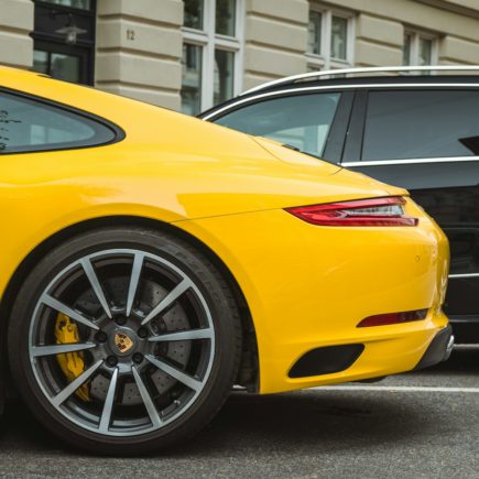 two yellow and black vehicles parked near gray concrete building