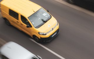 a yellow car and a white car on a road