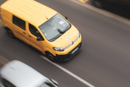 a yellow car and a white car on a road